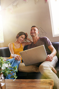 这是最有趣的视频 一个快乐的年轻夫妇 用笔记本电脑一起在家沙发上图片