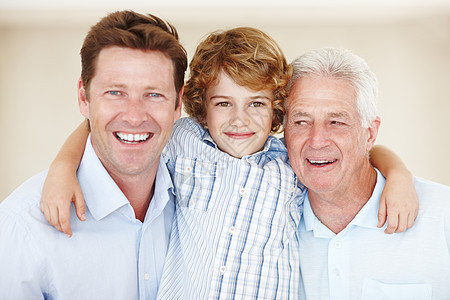 爷爷的掌上明珠 一个小男孩与他的父亲和祖父站在一起的裁剪肖像图片