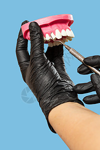 牙科医生的手有人类下巴和中间工具的布局治疗牙科医疗橡皮口腔科药品牙医诊所外科牙齿图片