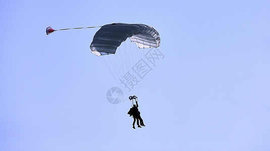 蓝天和白云对面有白色降落伞树冠的天空潜水器 近距离接近活动跳伞员肾上腺素空气俯冲蓝色自由天篷航班跳伞图片