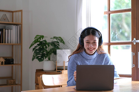 亚洲女学生在线学习班学习在线视频通话 zoom 老师 快乐的亚洲女孩用电脑笔记本电脑在线学习英语大学女士家庭作业桌子技术教育办公图片