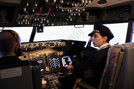 身穿制服 拥有驾驶舱指挥权的飞行飞机女副驾驶员图片