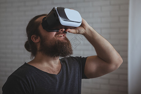 使用VR眼镜的兴奋男人手表创新娱乐行动胡须齿轮潮人风镜人士商业图片