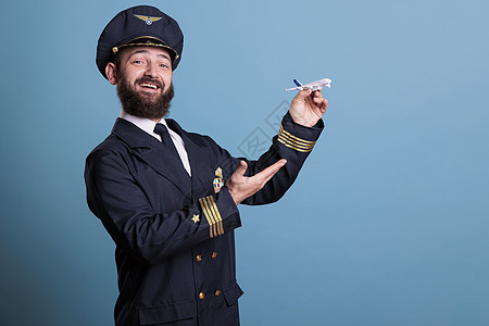 使用飞机型号玩弄制服的微笑飞行员图片
