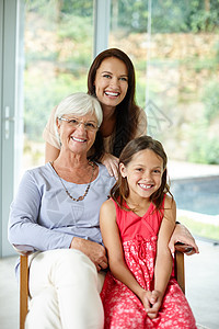 家里可爱的女士们 一个小女孩和她的母亲和祖母坐在家里的画像图片