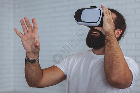 使用VR眼镜的兴奋男人展示行动商业创新电子游戏享受游戏娱乐胡须视频图片
