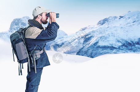 前往荒野 一位登山者使用他的双筒望远镜搜索风景图片