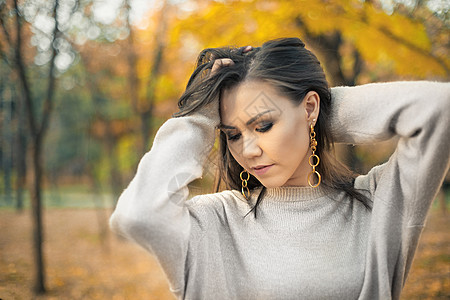 可爱的年轻混合种族女子时装 在户外秋天穿灰色毛衣图片