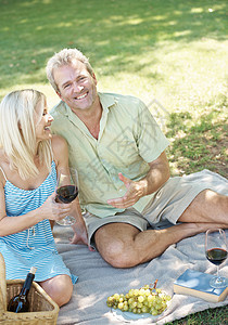 享受大自然的收获 夏日 一对幸福的丈夫和妻子在公园外野餐时享用一杯葡萄酒图片