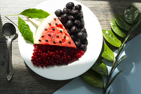 夏日零点 在配有绿叶植物的木制桌上新鲜果浆和水果桌子生活方式营养蓝色午餐盘子维生素三角形种子西瓜图片