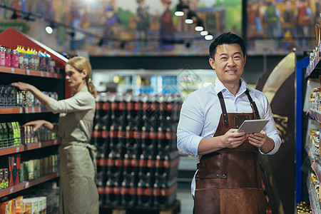 在一个超级超市中成功和快乐的亚洲卖方的肖像 一个穿着围裙的男人图片