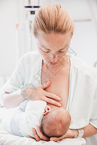 新母亲产后一天在医院为新生的婴儿喂奶 并仔细进行母乳喂养图片