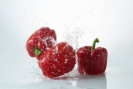 新鲜的胡椒落到清净的水中 白色背景下水时鲜红的胡椒蔬菜食物水果运动烹饪海浪生产液体辣椒节食图片