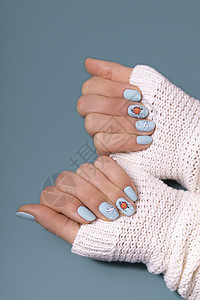 女性手用冬雪修指甲 在毛垫顶下贴上贴纸毛衣沙龙抛光手指女孩美甲艺术蓝色白色凝胶图片