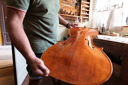 制琴师在车间将前桌固定到大提琴的肋骨上中提琴小提琴木头工艺芯片专注建设者工匠工具作坊图片