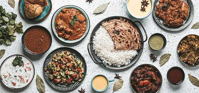 上面白色混凝土桌上的印度族裔食品自助餐餐厅烹饪芝士油炸小吃肉汁香菜草本植物送货盘子图片