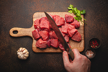 雄性手在木板上用立方体切生牛肉肉牛扒砧板牛肉食物乡村高架厨房美食烧烤羊肉图片