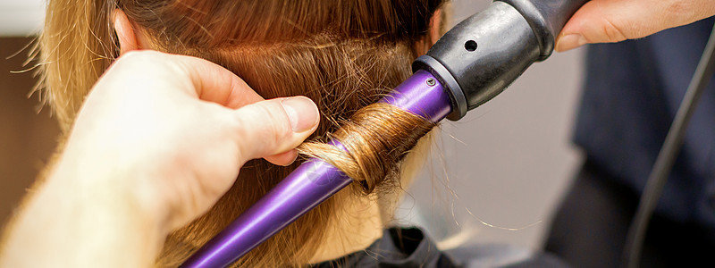 在美容院里用卷发铁 来做头发卷发的毛发冰壶魅力程度洗发水造型发型师客户商业女孩滚筒图片