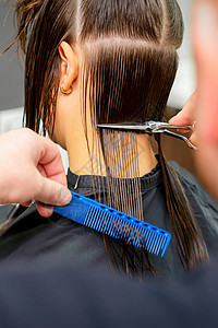 男理发师用剪刀和梳子把女客户的头发剪掉 在美容院里发型理发工作造型剪发服务梳妆台治疗成人店铺图片