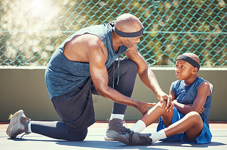 篮球膝盖受伤的孩子和爸爸一起在篮球场上为运动训练比赛事故提供紧急创可贴 非洲黑人父亲和受伤儿童团队治疗腿痛和伤口膏药图片