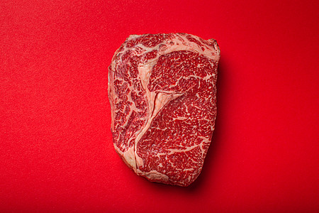 生肉牛肉优质切牛排 Ribeye 从上面干净的红色背景 牛排概念横幅极简主义店铺奶牛木板营养餐厅肋眼食物腰部炙烤烧烤图片