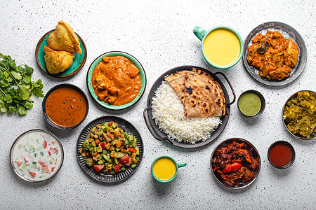 上面白色混凝土桌上的印度族裔食品自助餐芝士盘子小吃烹饪乡村香料异国情调送货餐厅图片