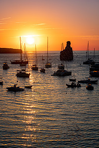 的夏季日落 船上有锚定船只海洋支撑港口蓝色假期海岸海景太阳地标橙子图片