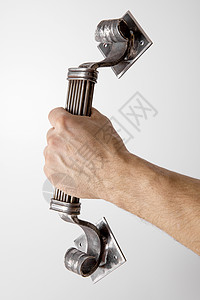 手拿着由铁匠制成的专属门把手 锻造 手工制作的手柄 特写视图 锻造生产 从金属的建筑细节 在白色背景的铁艺术品应用产品艺术男人建图片