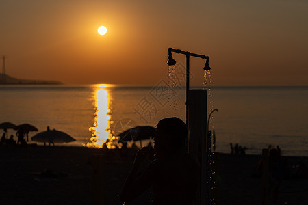 在海边游泳后洗个澡的月光 橙色日落海景的美丽景象 夏季度假胜地图片