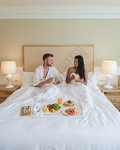 一对夫妇在床上吃早餐 一对男女在卧室里 清晨吃早餐丈夫沙拉幸福男朋友成人杯子女性男人男性咖啡图片