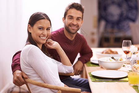 快乐的一对情侣享受餐桌旁的家庭大餐 大家一起吃饭图片
