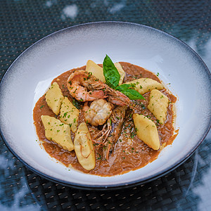 在泰国用红咖喱酱和虾肉 提供格诺奇意大利面图片