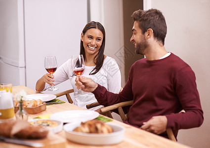让我们为餐桌上的食物干杯 一对快乐的情侣 享受全家在桌边吃饭图片