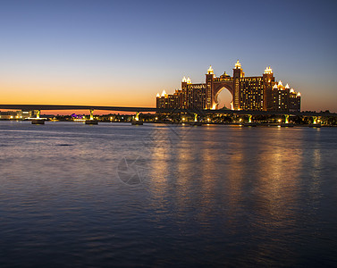 Atlantis 迪拜的五星级酒店很受欢迎 UAE在晚上 在照片中也可以看到通向旅馆的单轨铁路喷泉停留日落建筑旅游反射天空假期建背景图片