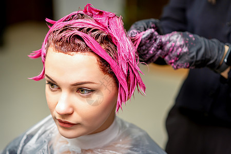 专业理发师用刷子把粉红色染色涂在头发上 毛发彩色概念美发职业顾客女性护理着色剂造型发型师沙龙女士图片