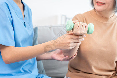 照顾者帮助满足的老年妇女在家用哑铃锻炼运动药品医生医院服务卫生女性保健品训练护士医学图片
