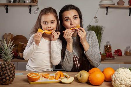 母亲和女儿正在做水果切菜 在厨房玩得开心些孩子用具妈妈食谱橙子父母家庭成人乡村菜单图片