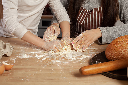 母亲和女儿正在烤面包 在厨房玩得开心 笑声牛奶家务食物食谱面粉黑发童年母性女士面团图片