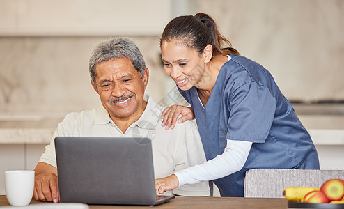 快乐的护士用笔记本电脑帮助老人 展示如何在辅助生活之家进行视频通话或搜索互联网 老年患者与医护人员共度时光 阅读在线新闻图片