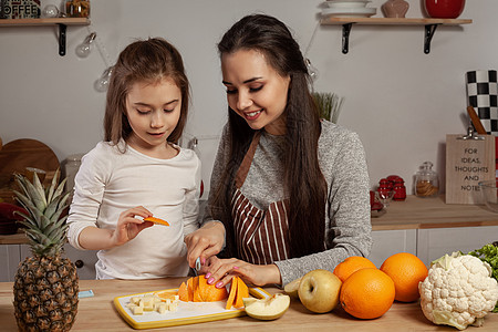 母亲和女儿正在做水果切菜 在厨房玩得开心些营养孩子们食谱烹饪妈妈家务食物橙子乡村菠萝图片