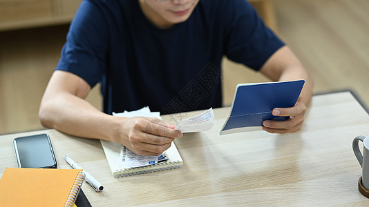 严肃的千禧一代男子在客厅管理家庭开支的镜头图片