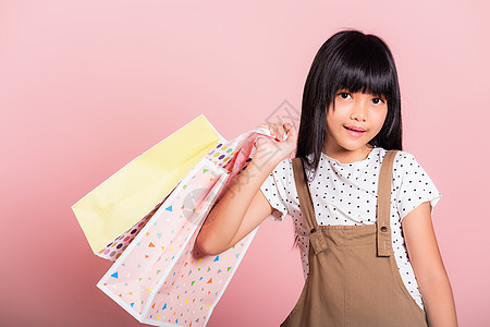 10岁的亚洲小孩笑着把多彩购物袋握在手里消费者销售假期礼物女性展示旅行孩子购物者孩子们图片