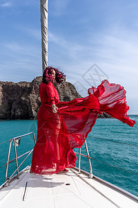 夏日在游艇上穿着红色礼服的中年女子 有吸引力的中年妇女 豪华暑假冒险 户外活动女士运输微笑船长航行双体海滩巡航海洋幸福图片