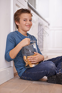 还有一个 一个男孩坐在厨房地板上 还拿着个饼干罐子图片