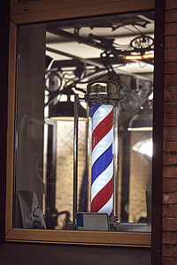 一家理发店的著名标志 上面有红色 蓝色和白色条纹胡须沙龙螺旋形发型男人旋转玻璃螺旋店铺圆柱图片
