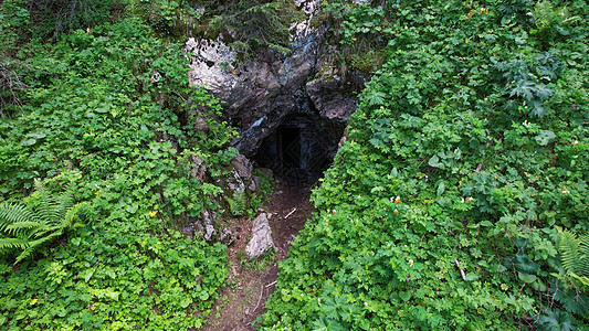 岩洞的入口被绿色遮蔽了黑暗植物地牢峡谷探索风景岩石考古学踪迹编队图片