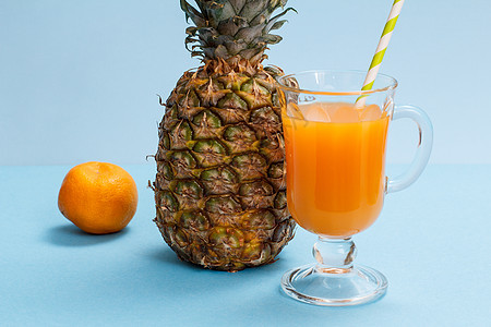 蓝色背景的新鲜热带水果和果汁杯图片