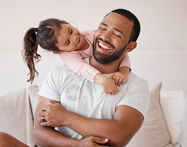 家庭拥抱 幸福的爱和父亲在家里的沙发上为孩子微笑 照顾孩子 在客厅里一起度过周末 女孩在休息室的沙发上放松时拥抱爸爸图片