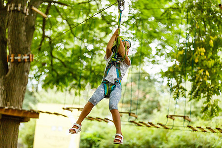 快乐的学校女孩在暑假享受在一个爬山冒险公园的活动活动冒险危险森林探索自由风险娱乐公园安全运动图片
