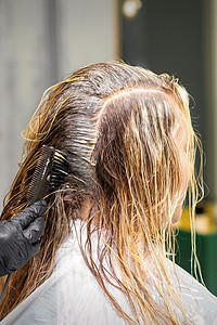 黑手套理发师对顾客的头发涂了刷子颜色 在美容院特写时染发成人服务客厅工作室发型护理客户造型染料职业图片